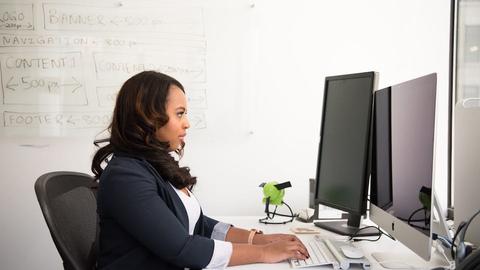 A woman sitting in front of a computer at a desk