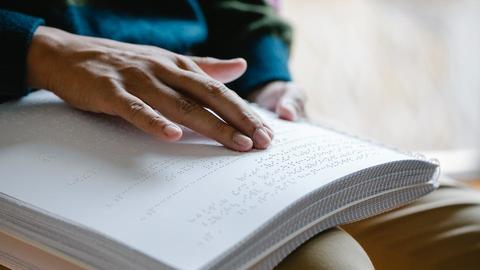 a person reading a book written in braille