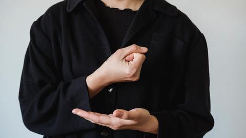 A torso of a person doing American Sign Language