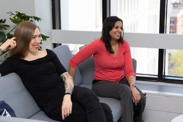 Two women sitting on a bench seat 