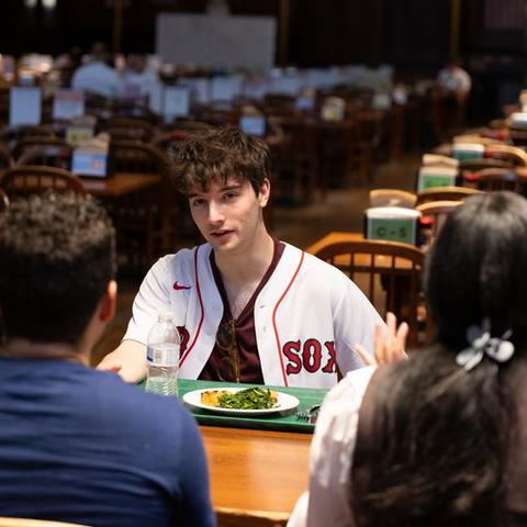 College student talking with other students in the dining hall 