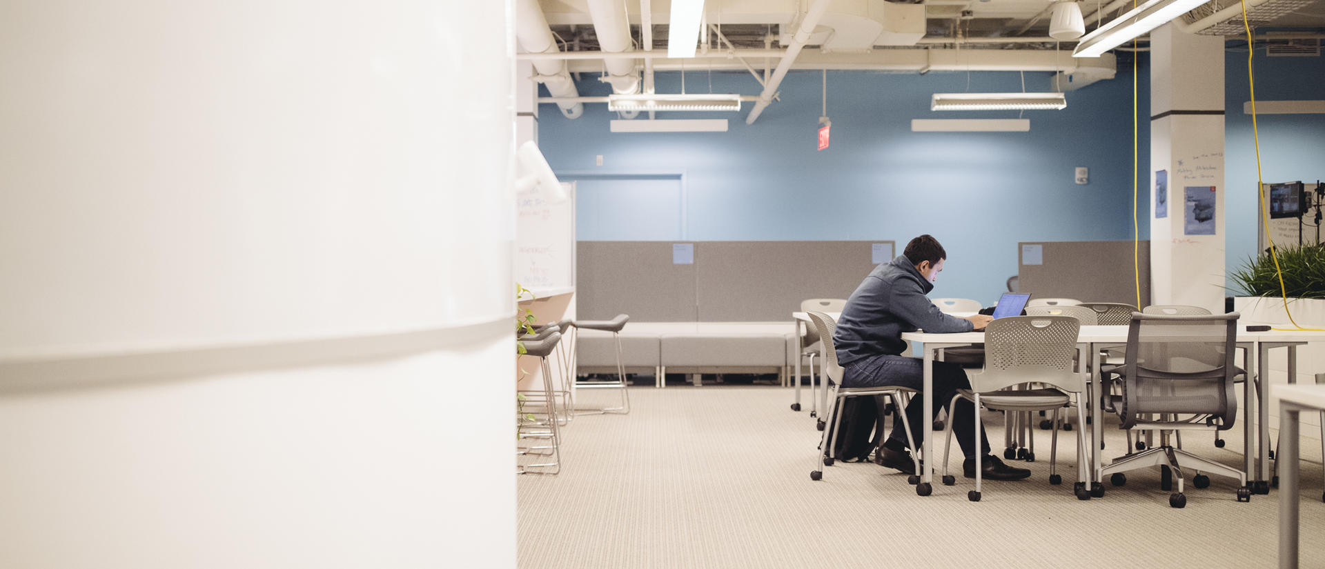 Student sitting alone in a room with his laptop