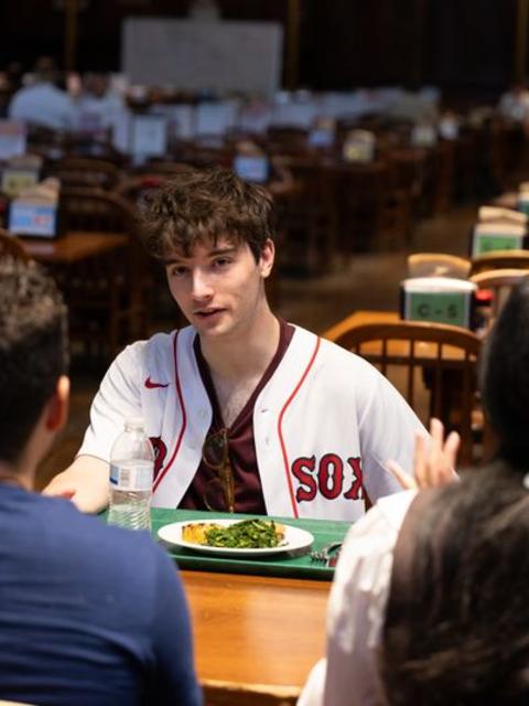 College student talking with other students in the dining hall 